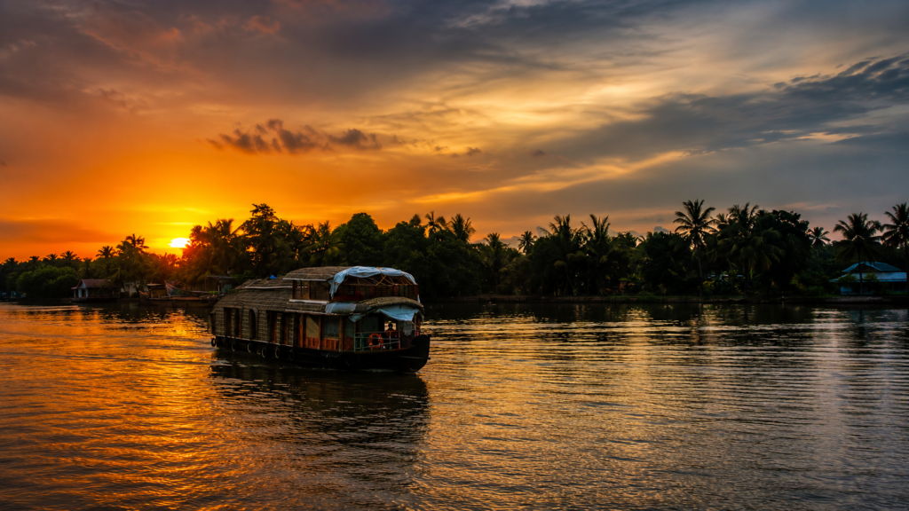 Sunset over Alappuzha backwaters with a traditional boat