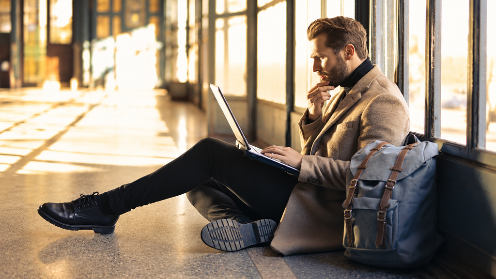 Traveler searching for cheap flights on a laptop at an airport
