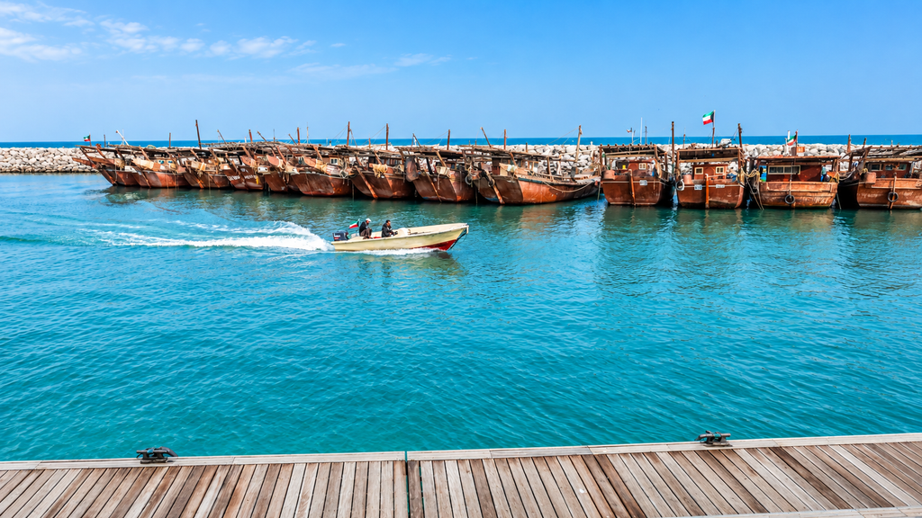 Musandam mountains and traditional dhow boat in Oman
