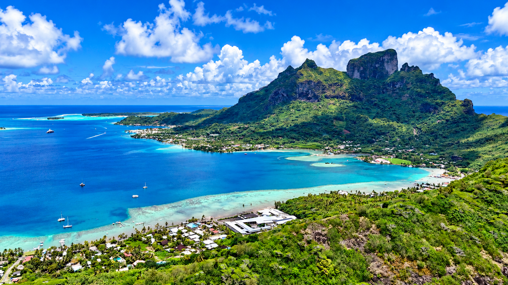 Bora Bora lagoon with tropical beach and green mountains