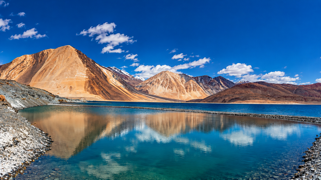  Blue water and rugged Himalayan mountains surrounding Pangong Lake in Ladakh.
