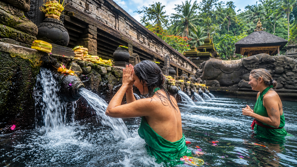Visitor wearing a sarong at the water spouts of Tirta Empul temple in Bali.
