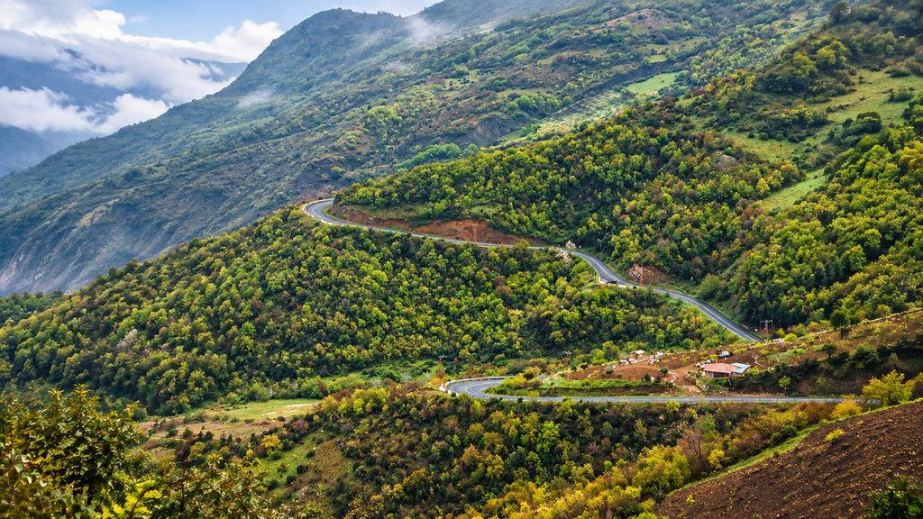 Winding hill road surrounded by green vegetation near Madikeri, Coorg.